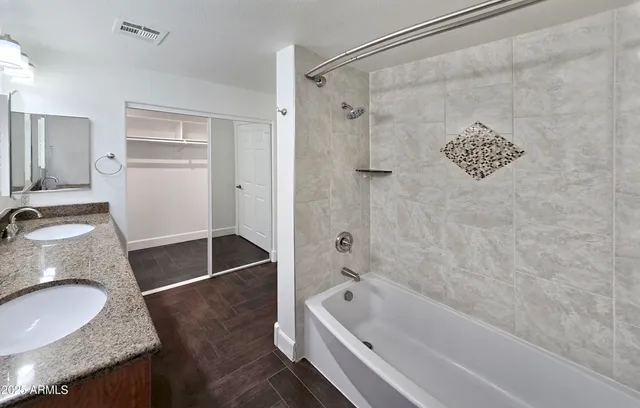 a bathroom with a granite countertop tub sink and mirror