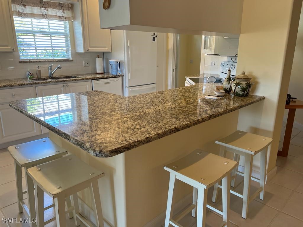 3013 Futuna Lane Naples, FL 34119 - Photo 9 of 21 a kitchen with stainless steel appliances granite countertop a sink counter space and cabinets