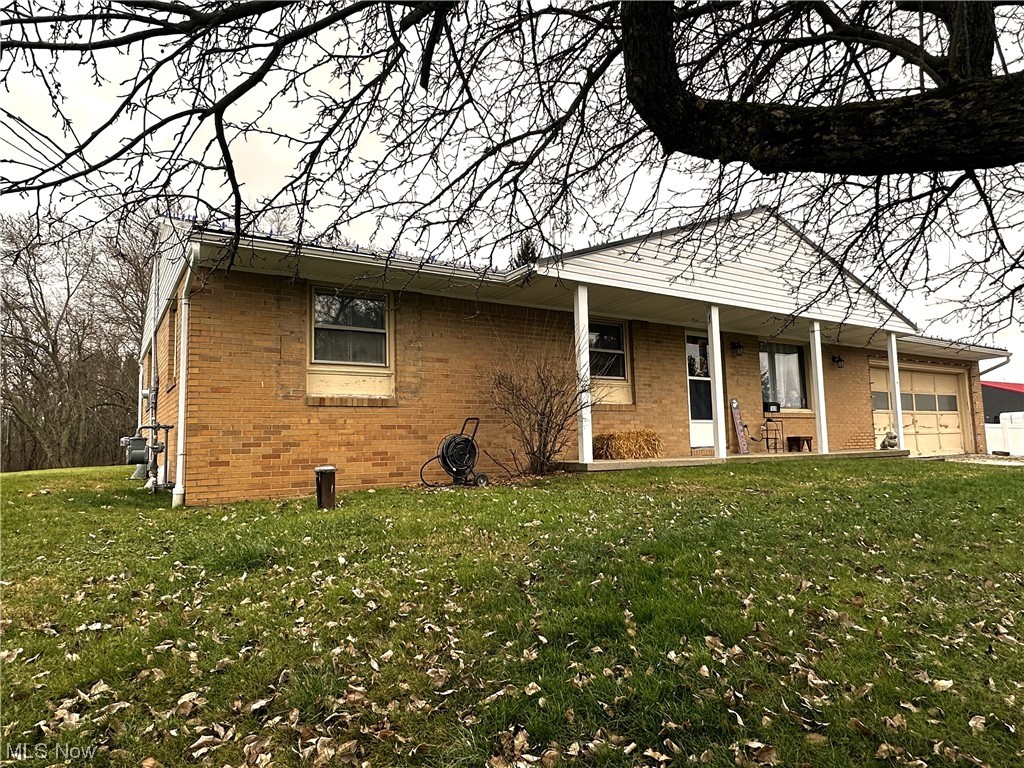 View of front of home with a front yard and a garage