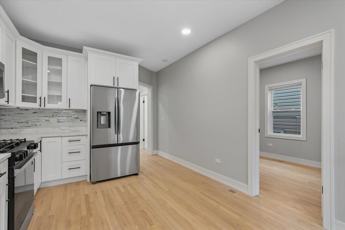 2159 North Parkside Avenue Chicago, IL 60639 - Photo 23 of 27 a kitchen with granite countertop a refrigerator and a stove top oven