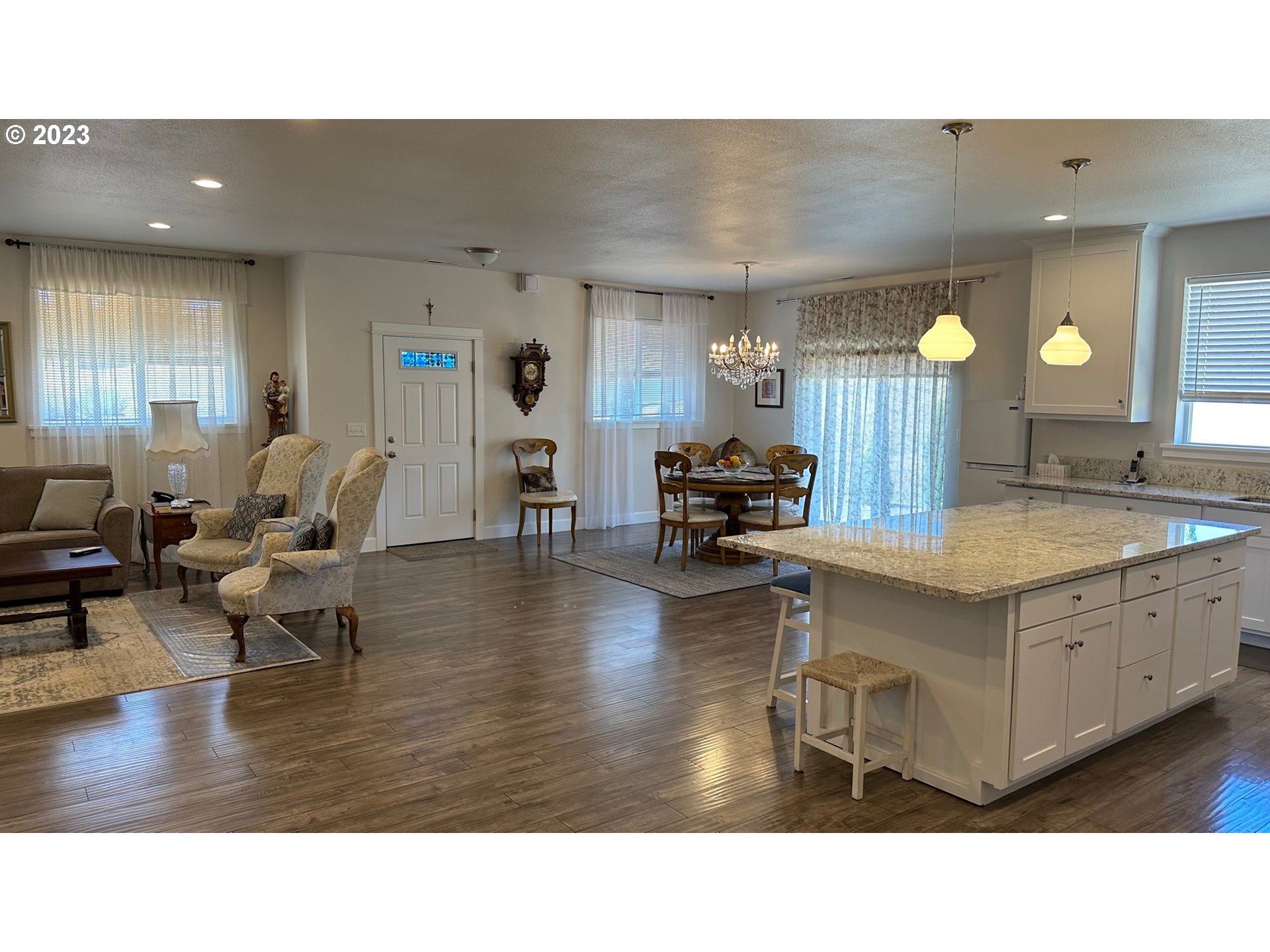 746 Divot Loop Sutherlin, OR 97479 - Photo 24 of 32 a living room with couches and kitchen view with wooden floor
