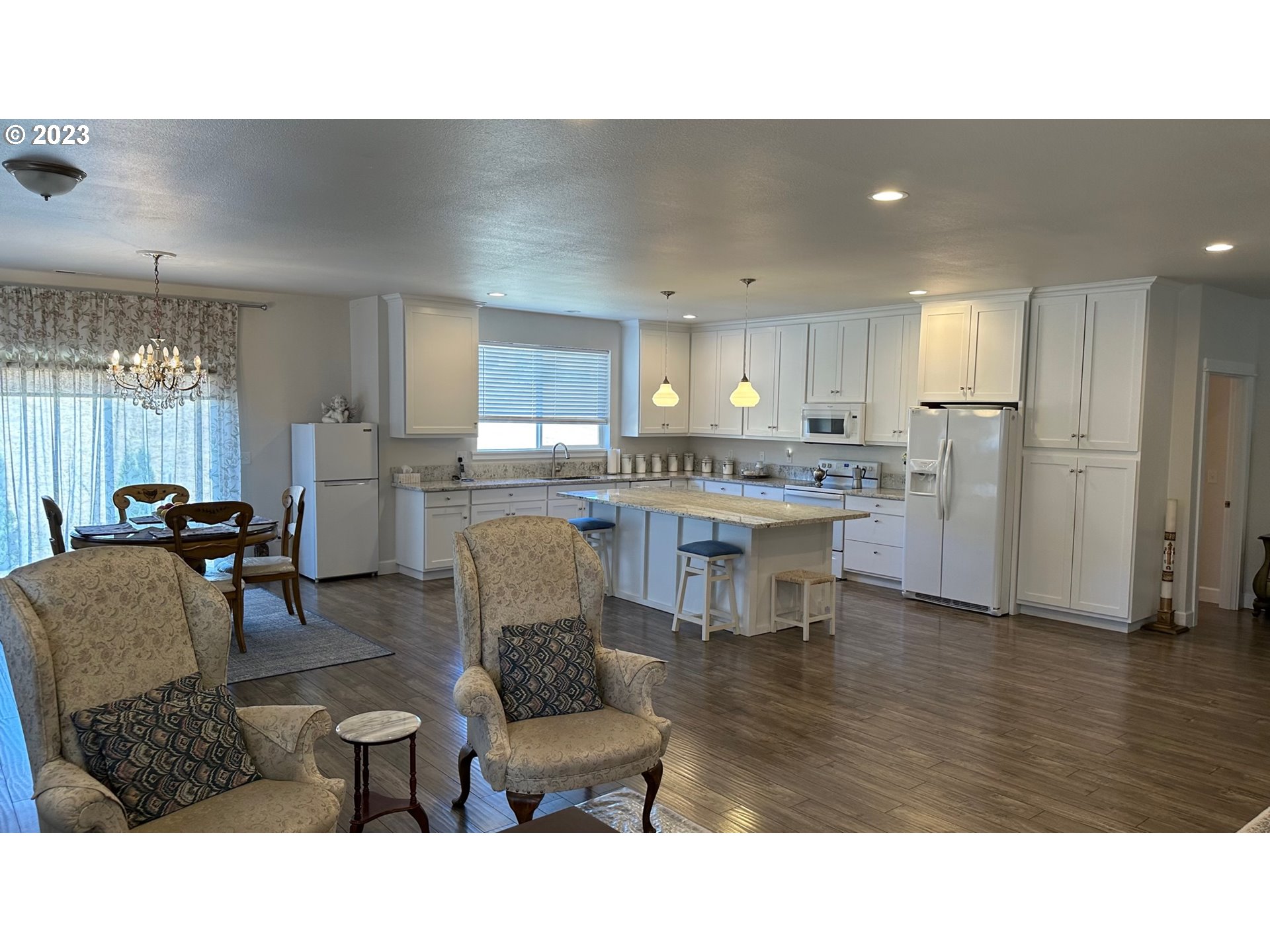 746 Divot Loop Sutherlin, OR 97479 - Photo 25 of 32 a living room with stainless steel appliances kitchen island granite countertop a dining table chairs and a refrigerator