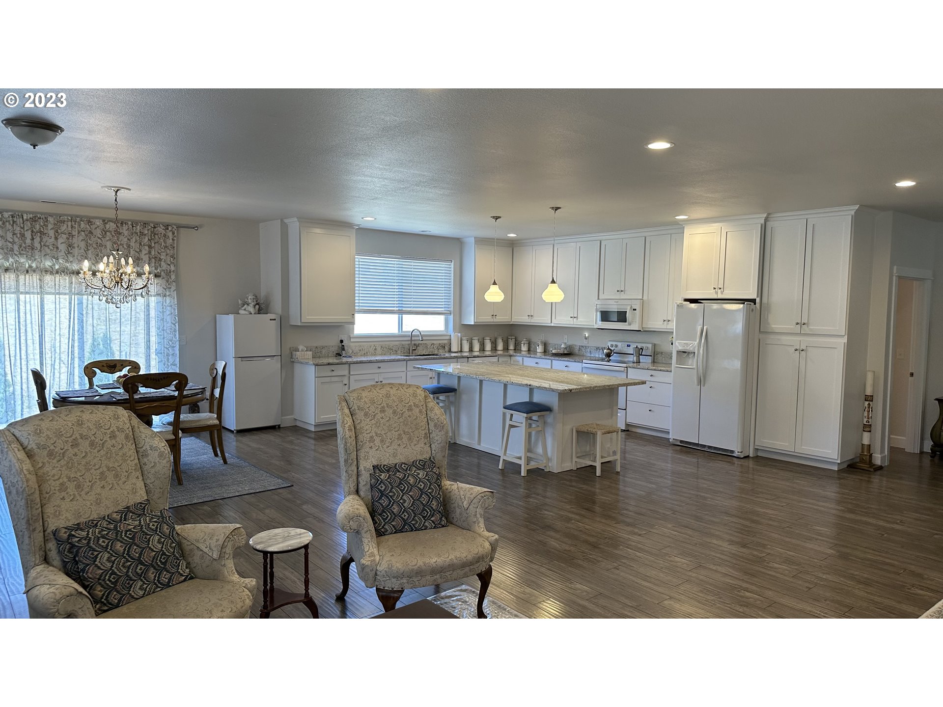 746 Divot Loop Sutherlin, OR 97479 - Photo 27 of 32 a living room with stainless steel appliances kitchen island granite countertop a dining table chairs and a refrigerator