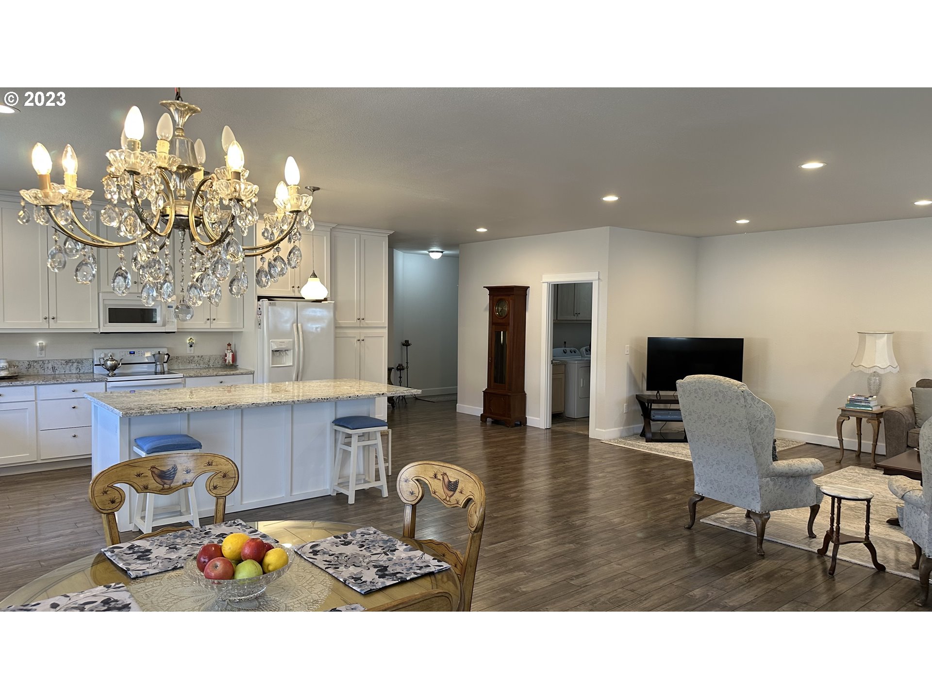 746 Divot Loop Sutherlin, OR 97479 - Photo 29 of 32 a living room with furniture a chandelier and a wooden floor