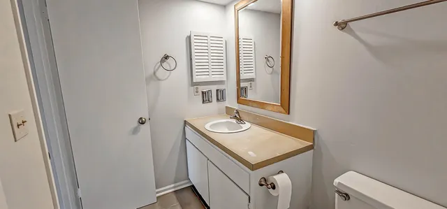 a bathroom with a sink a toilet and a mirror