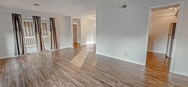 an empty room with wooden floor and a window