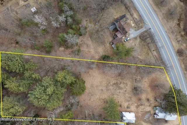 a view of a dry yard with wooden fence
