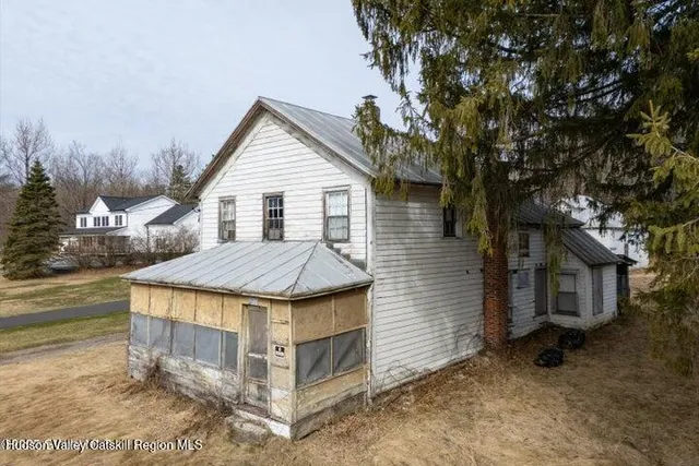 a wooden house with a tree in front of it