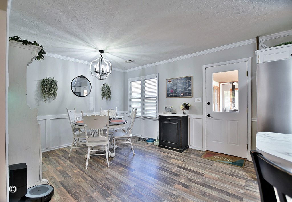 129 Hunter Road Cataula, GA 31804 - Photo 13 of 28 a dining room with wooden floor a chandelier a wooden table and chairs