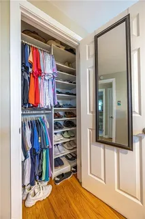 a view of walk in closet with clothes and shoes