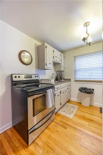 a kitchen with granite countertop a stove a sink and a microwave