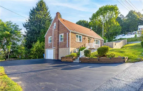 a front view of a house with a yard and potted plants