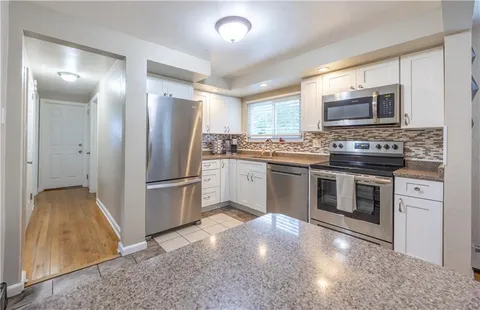 a kitchen with stainless steel appliances a stove a sink and a refrigerator