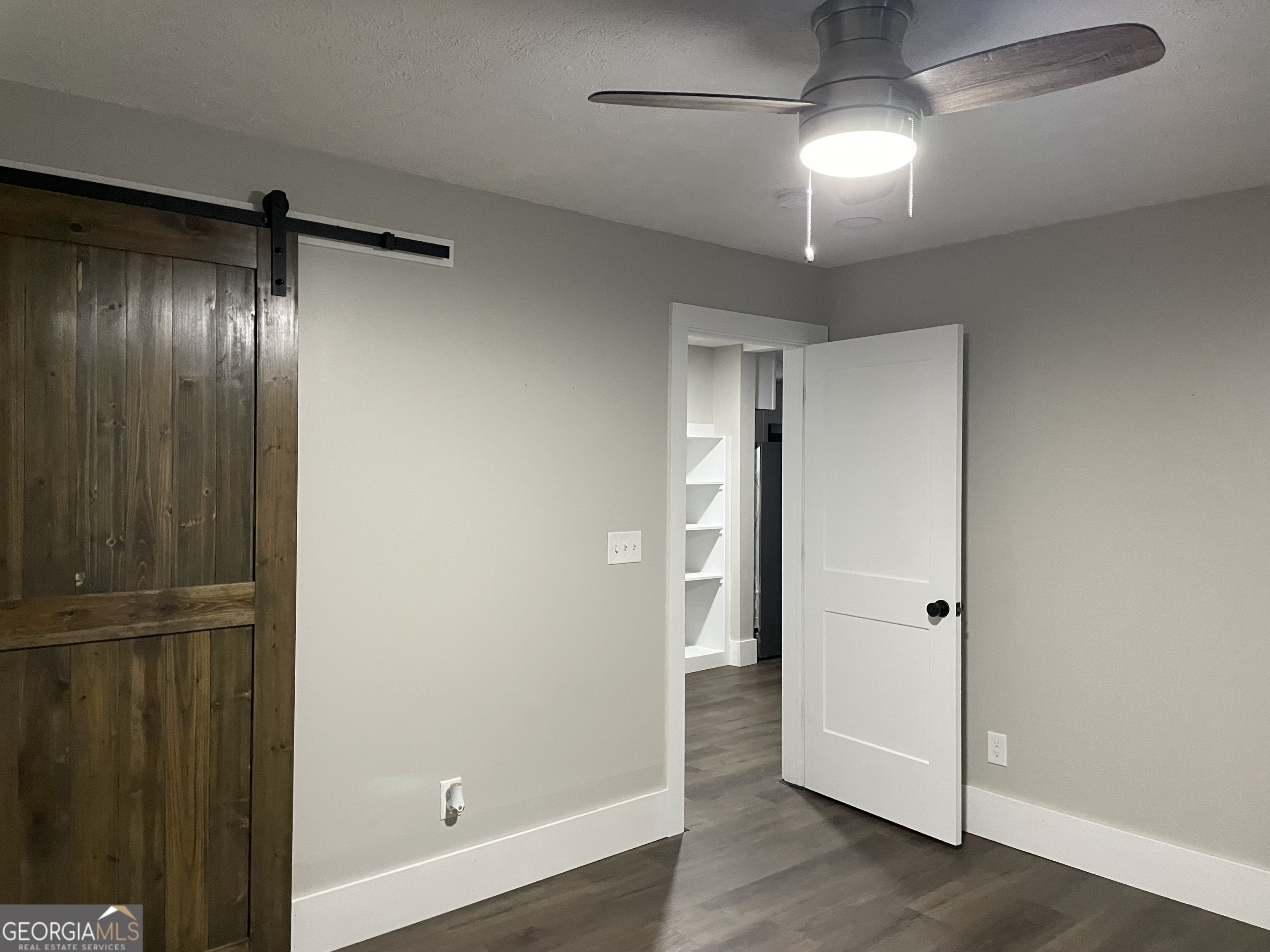 5186 Wheat Street Northeast Covington, GA 30014 - Photo 5 of 10 an empty room with wooden floor cabinet and windows
