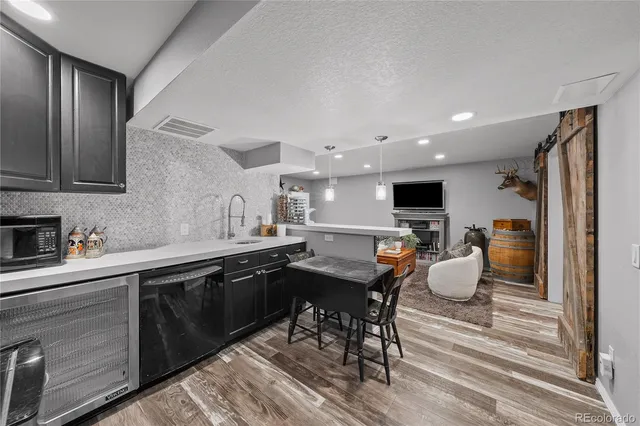 a kitchen with a sink a stove cabinets and wooden floor
