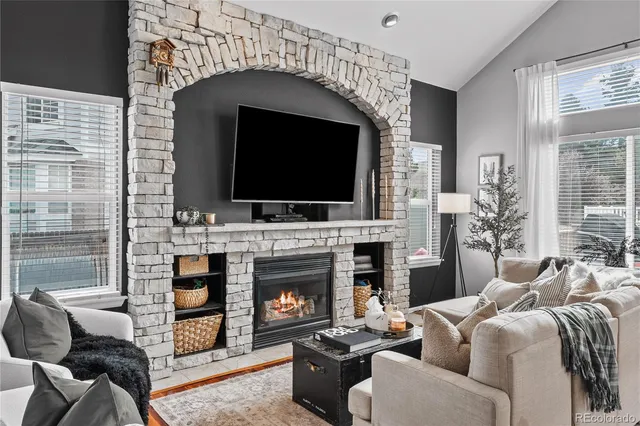 a living room with furniture a flat screen tv and a fireplace