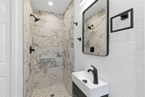 a bathroom with a shower and mirror