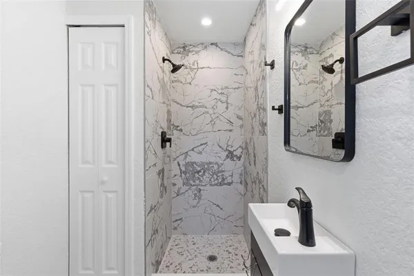 a bathroom with a shower and mirror