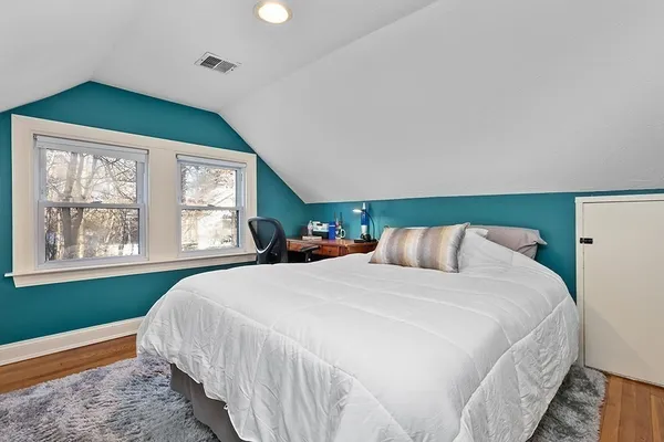 a bedroom with a bed a mirror and lamp