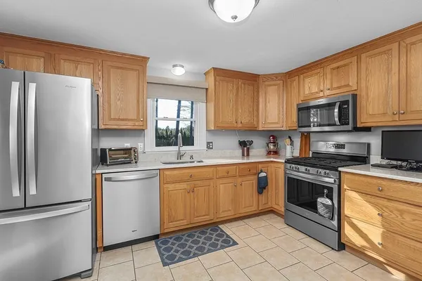 a kitchen with stainless steel appliances granite countertop a stove top oven a refrigerator and white cabinets with granite countertops