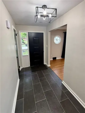 a view of a hallway with wooden floor and a bathroom
