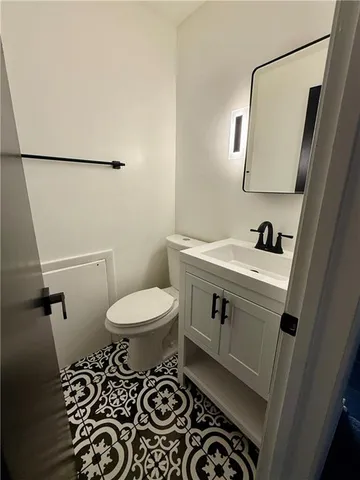 a bathroom with a sink toilet and a mirror