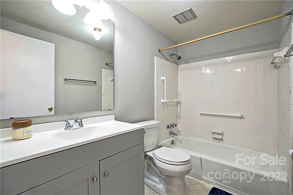 5925 Quail Hollow Road, Unit F Charlotte, NC 28210 - Photo 13 of 14 a bathroom with a sink a toilet a mirror and shower
