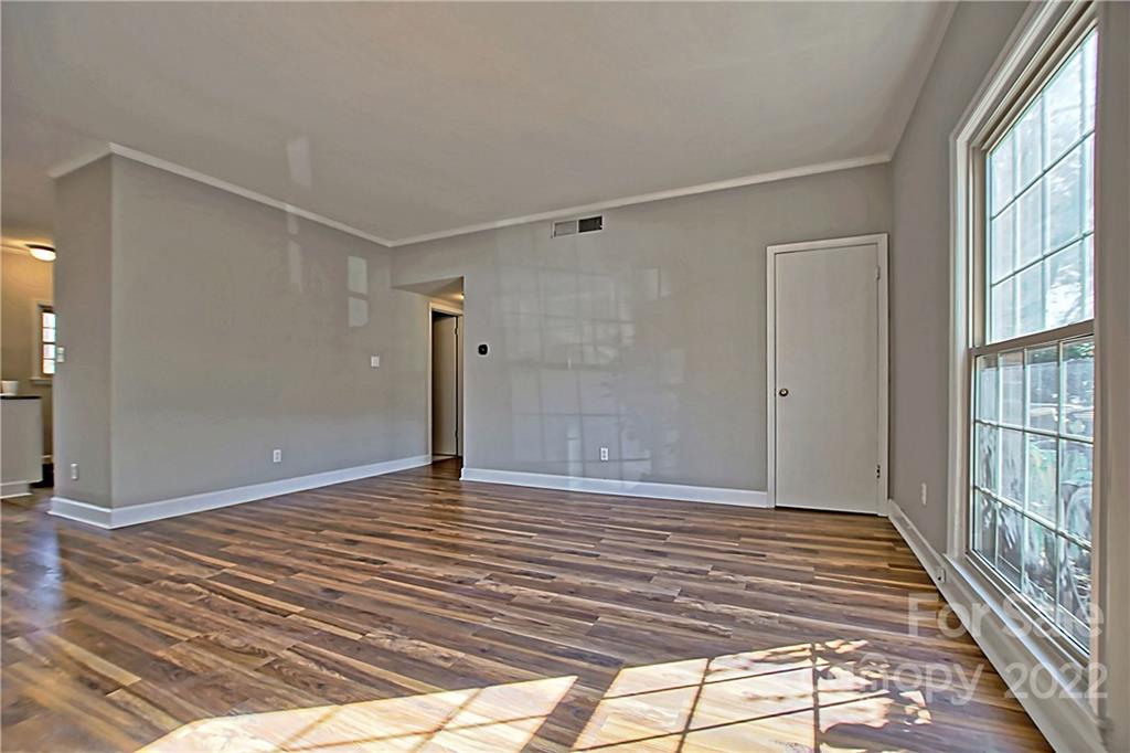 5925 Quail Hollow Road, Unit F Charlotte, NC 28210 - Photo 3 of 14 a view of an empty room with wooden floor and a window