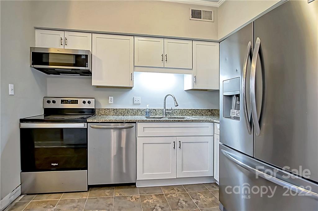 5925 Quail Hollow Road, Unit F Charlotte, NC 28210 - Photo 5 of 14 a kitchen with stainless steel appliances granite countertop a refrigerator stove top oven and sink