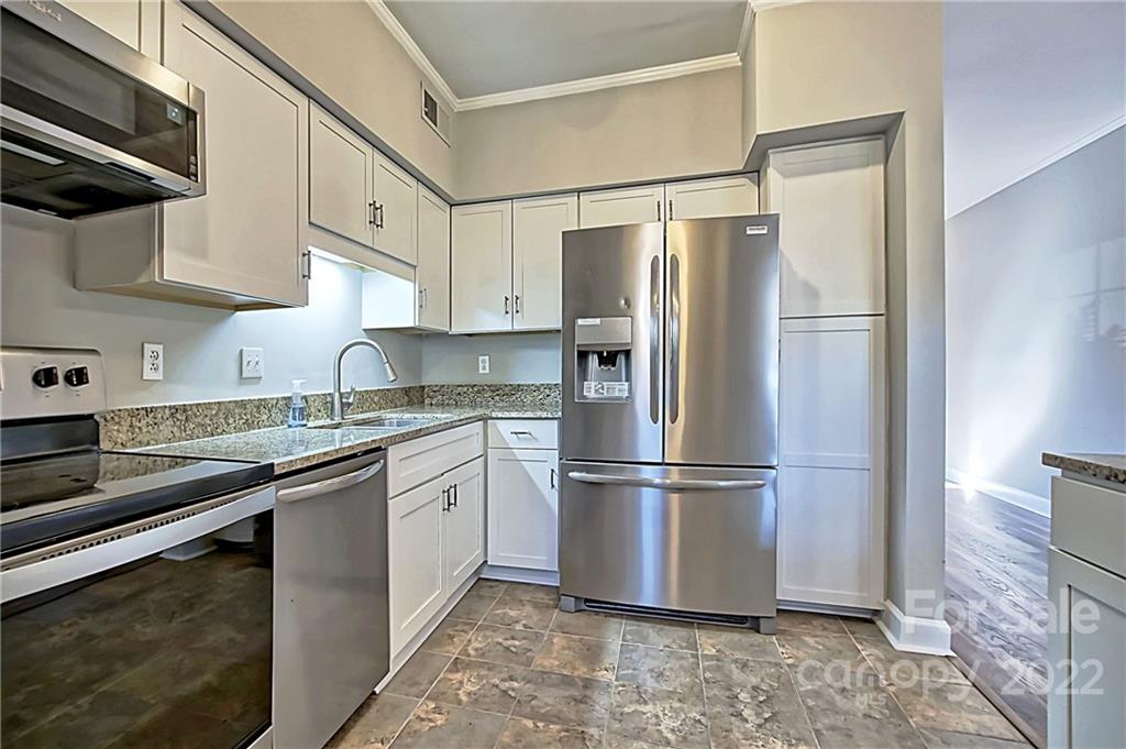 5925 Quail Hollow Road, Unit F Charlotte, NC 28210 - Photo 6 of 14 a kitchen with stainless steel appliances granite countertop a refrigerator a sink and white cabinets