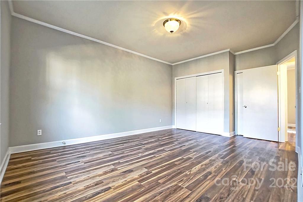 5925 Quail Hollow Road, Unit F Charlotte, NC 28210 - Photo 9 of 14 a view of an empty room with wooden floor and a window