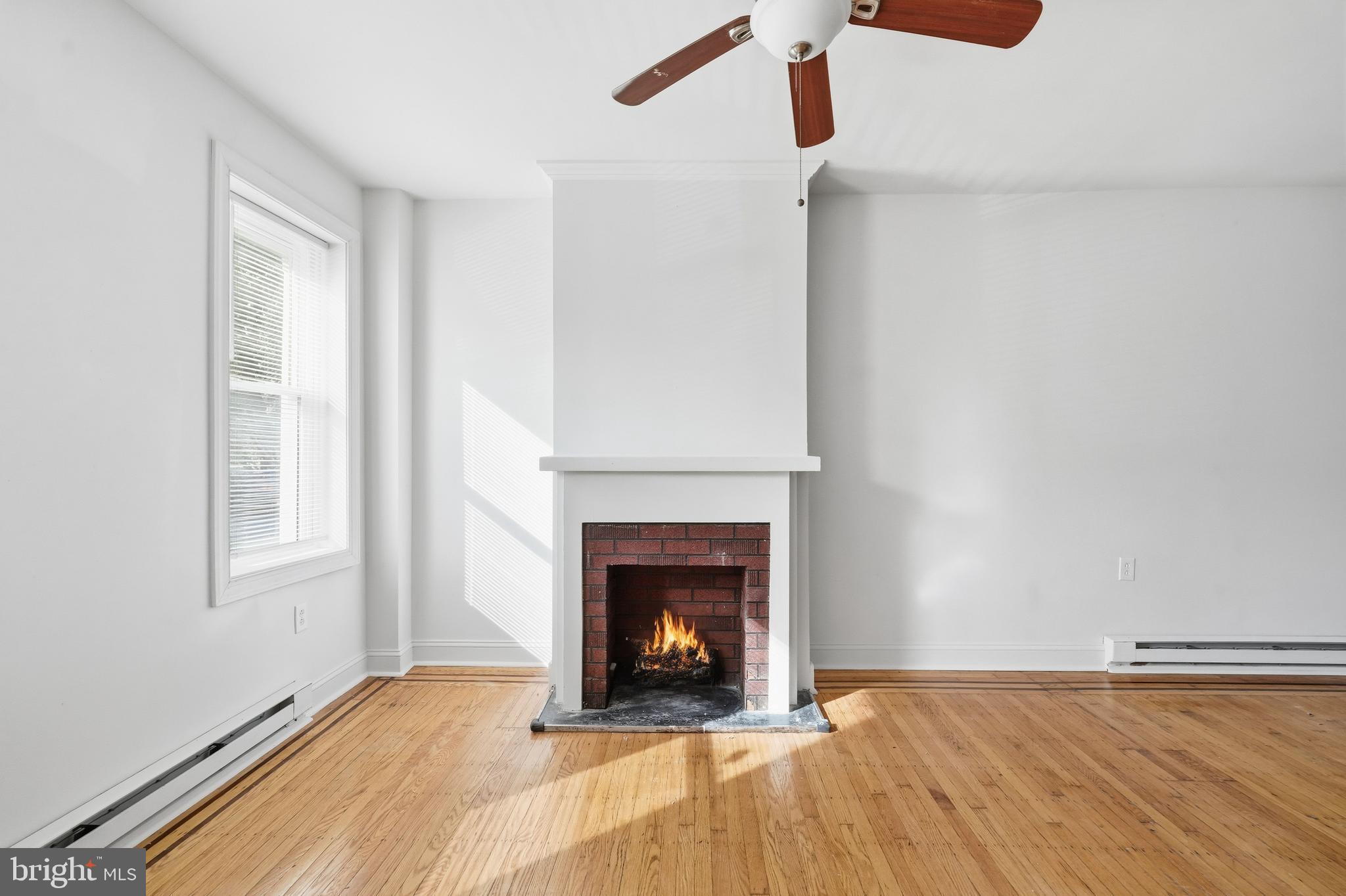 2333 East Huntingdon Street Philadelphia, PA 19125 - Photo 7 of 26 a view of an empty room with wooden floor fireplace and a window