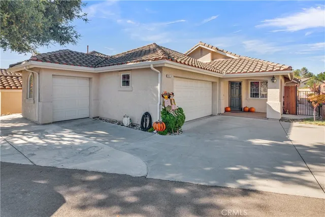a view of a white house with large windows and a table and chairs in a yard