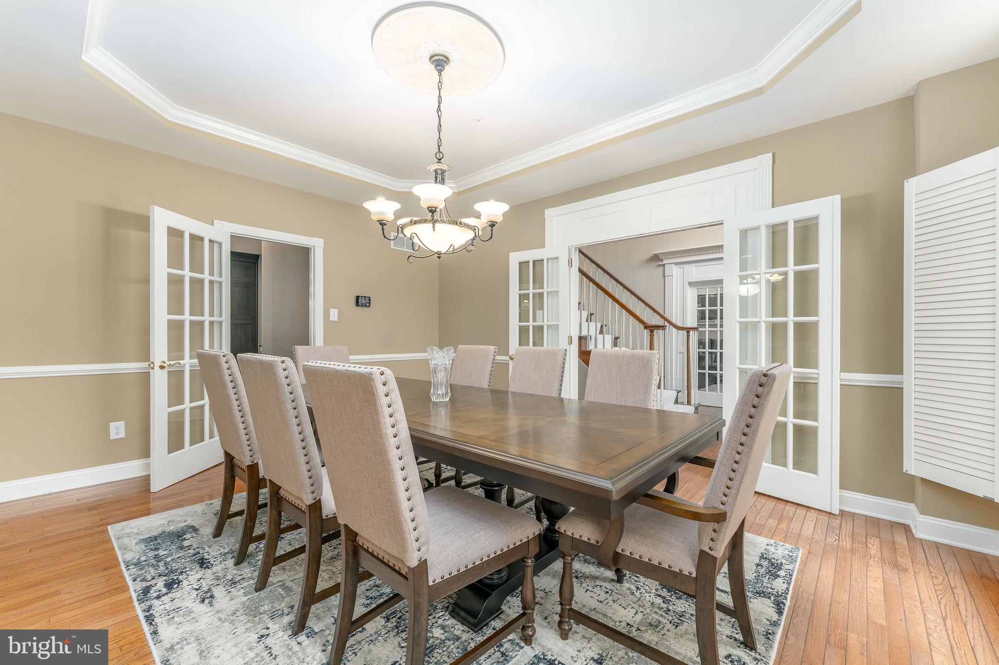 300 Bell Court Exton, PA 19341 - Photo 17 of 79 a dining room with wooden floor a chandelier a wooden table and chairs