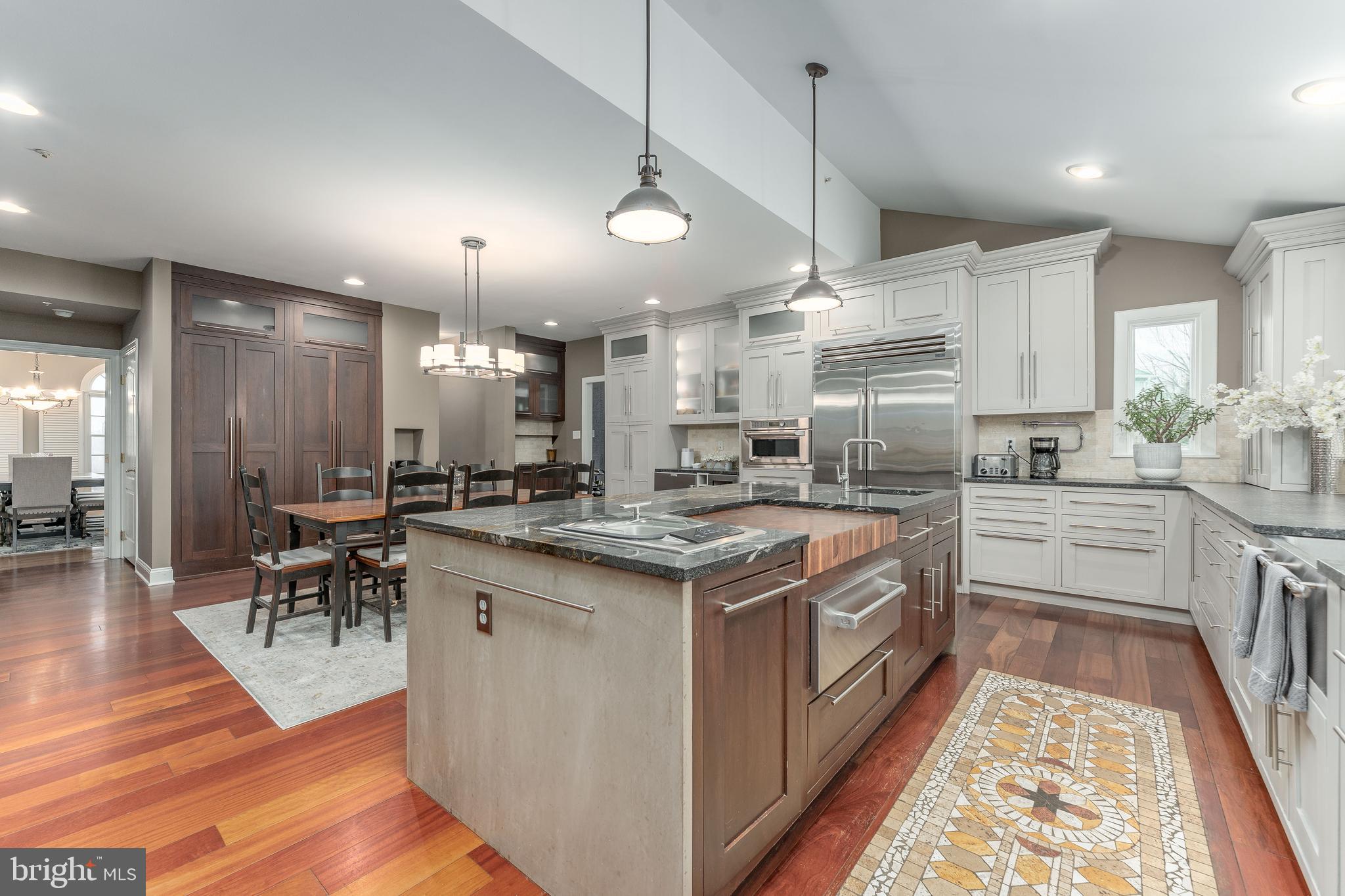 300 Bell Court Exton, PA 19341 - Photo 32 of 79 a kitchen with stainless steel appliances granite countertop a table chairs stove a sink dishwasher a kitchen island with wooden floor