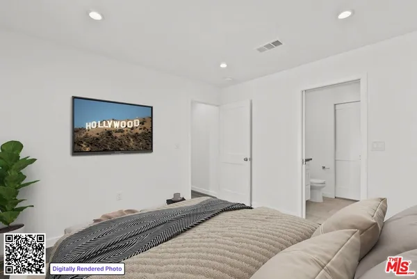 a bedroom with a bed and a painting on the wall