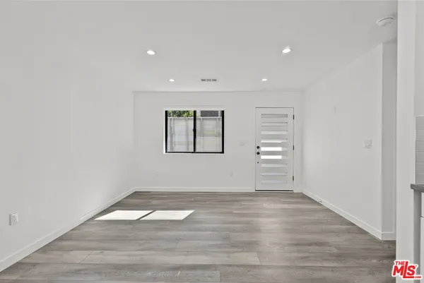 a view of empty room with wooden floor