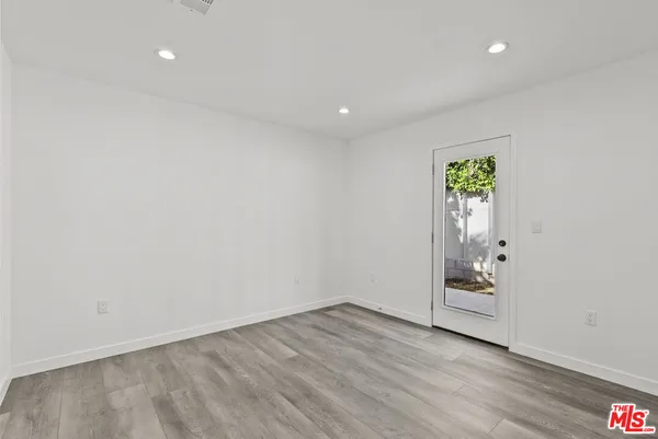 an empty room with wooden floor and white walls