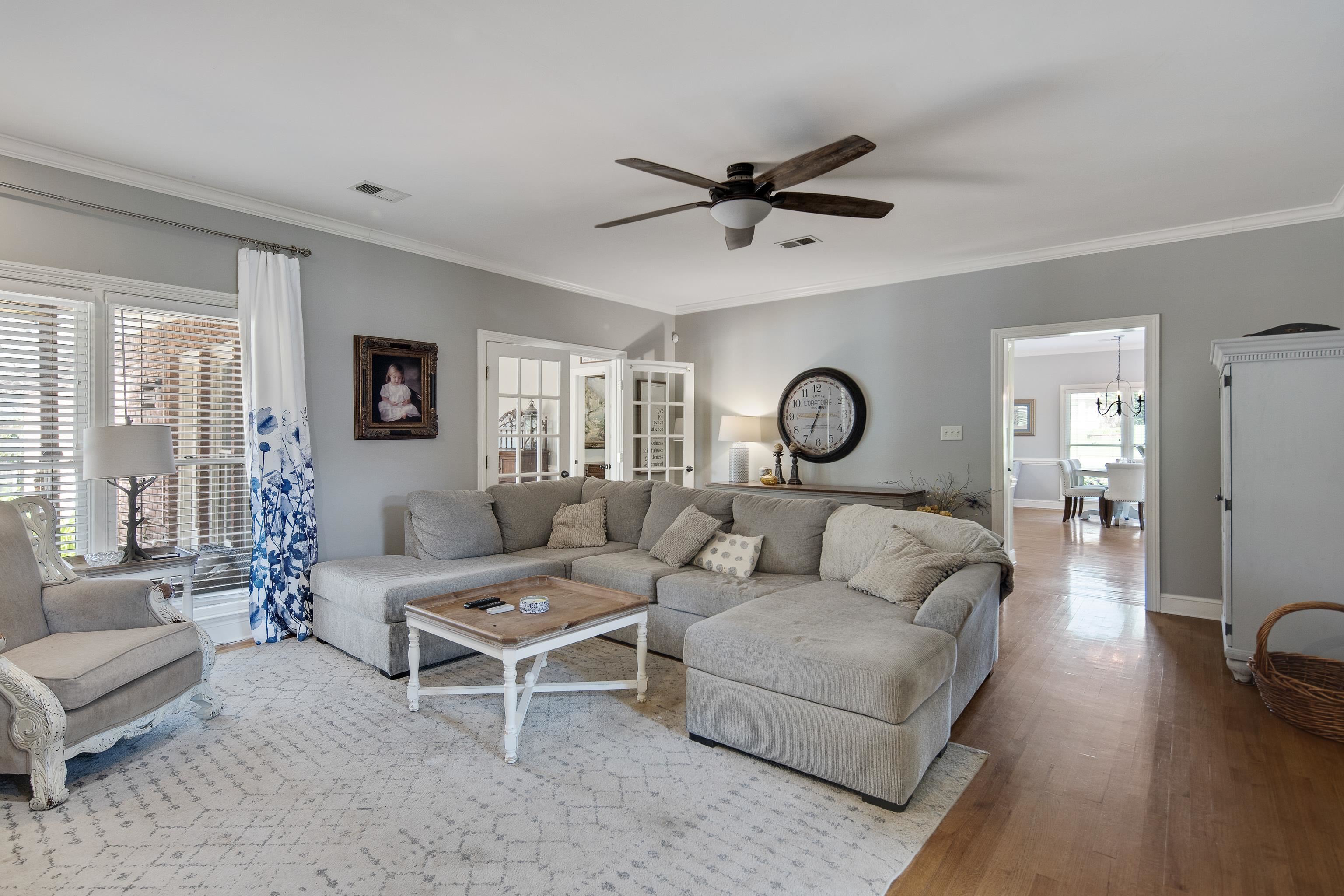 1323 Colbert Cove Collierville, TN 38017 - Photo 11 of 40 Living room with ceiling fan with notable chandelier, wood-type flooring, and ornamental molding
