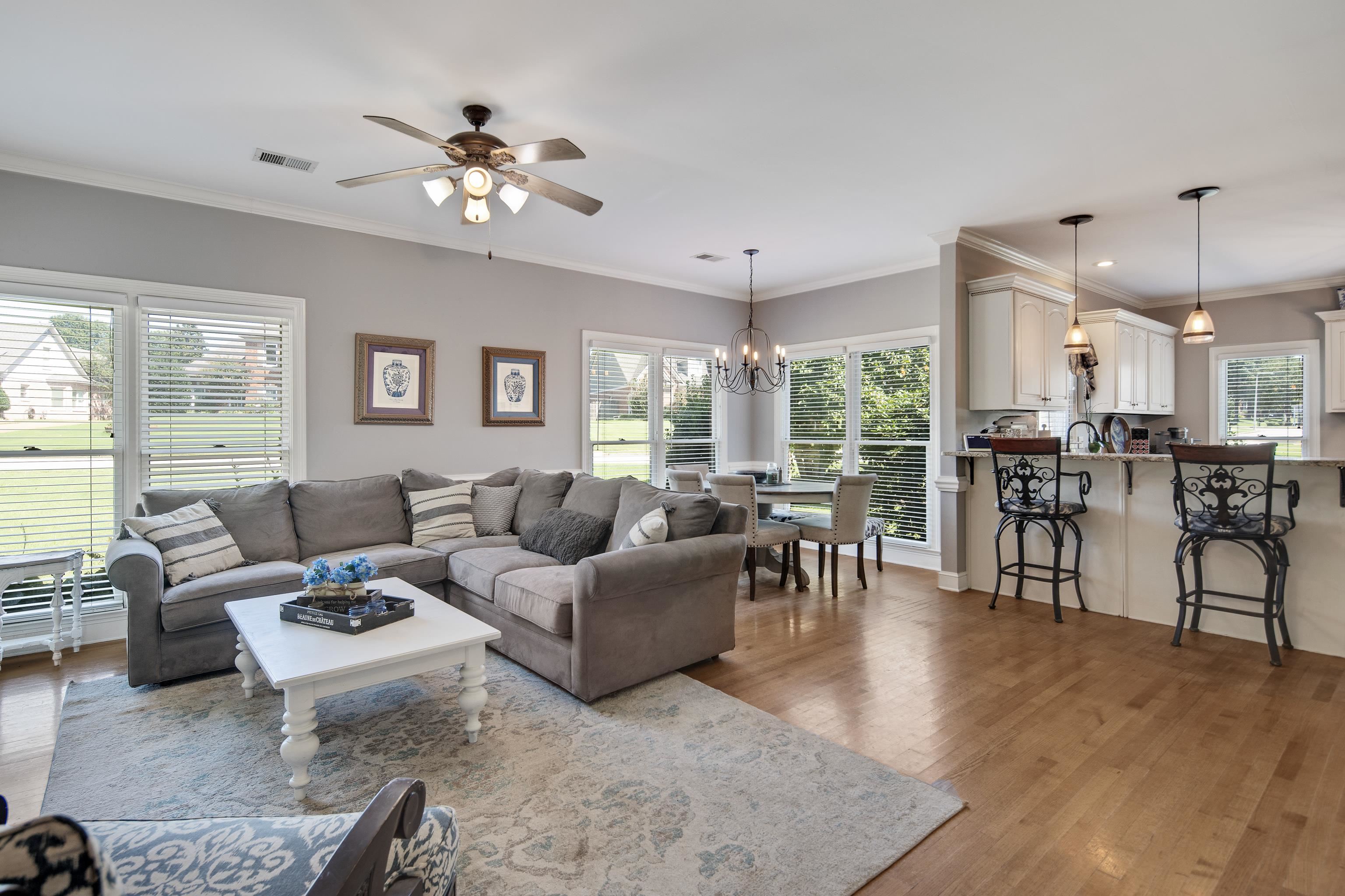 1323 Colbert Cove Collierville, TN 38017 - Photo 17 of 40 Living room featuring ceiling fan with notable chandelier, crown molding, sink, and light hardwood / wood-style flooring