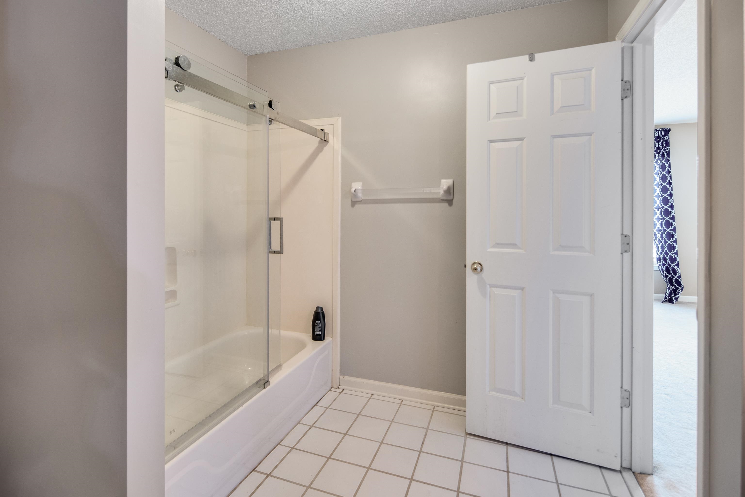 1323 Colbert Cove Collierville, TN 38017 - Photo 34 of 40 Bathroom featuring a textured ceiling, combined bath / shower with glass door, and tile patterned floors