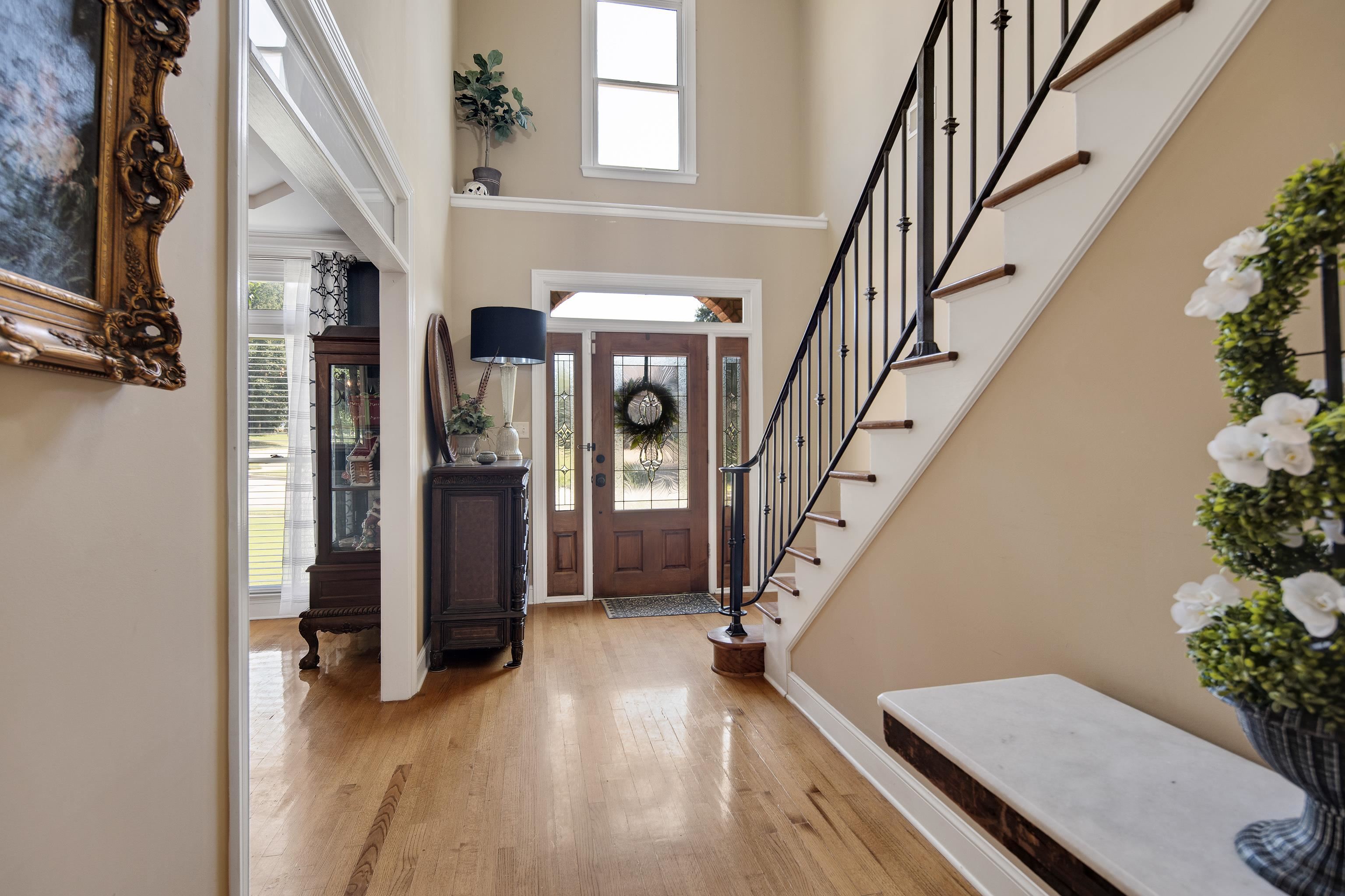 Entrance foyer with a high ceiling, light hardwood / wood-style floors, and plenty of natural light