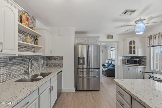 a kitchen with a center island wooden floor and stainless steel appliances