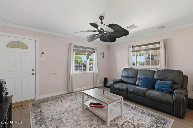 a living room with furniture a ceiling fan and a window