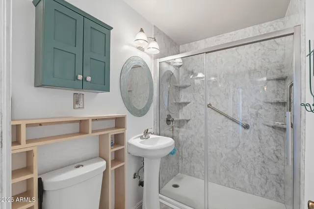 a bathroom with a sink a toilet and shower