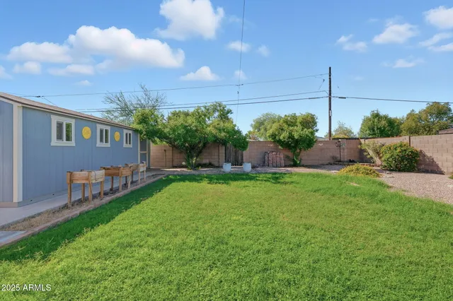 a view of house with backyard and a garden