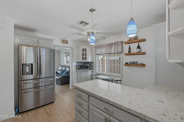 a kitchen with granite countertop a refrigerator and a sink