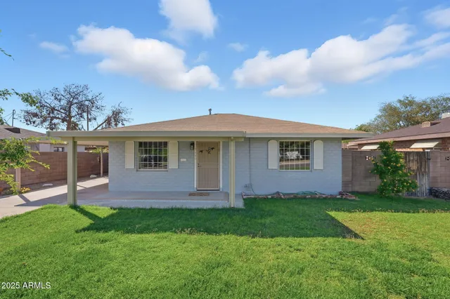 a front view of a house with a yard and green space