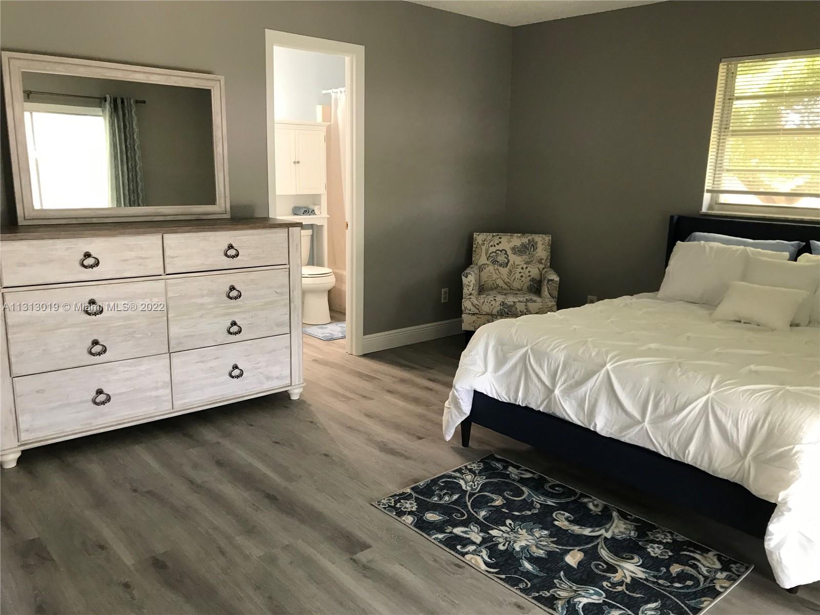 a bedroom with a bed and a mirror on dresser