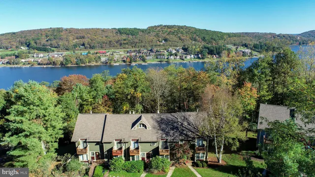 an aerial view of a house with a garden and lake view